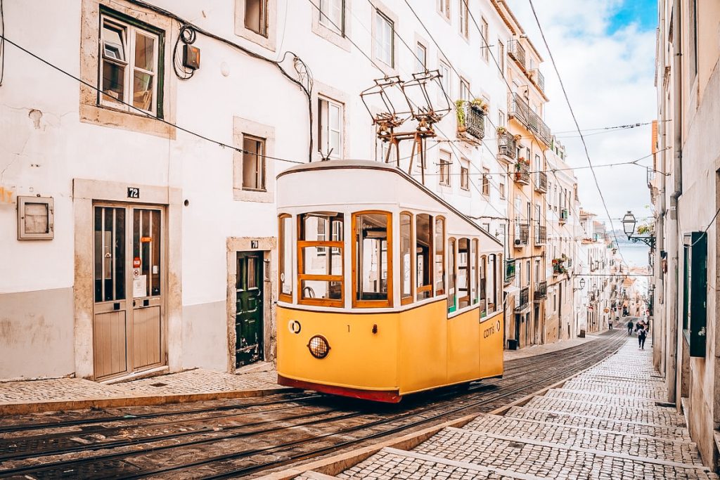 The Best Countries for First-Time Travellers (Budget-Friendly Picks): Iconic yellow tram on a steep cobblestone street in Lisbon, Portugal.